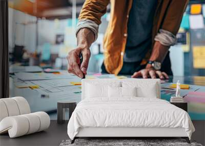 A man is writing on a white board with a pen. The board is covered in colorful sticky notes Wall mural