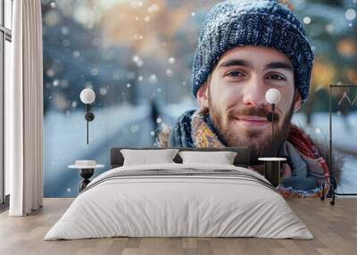 A man wearing a blue hat and scarf is smiling in the snow Wall mural