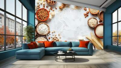 A variety of grains and nuts are displayed in bowls on a white background Wall mural