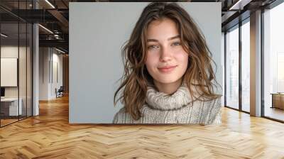 A woman with brown hair and a white sweater is smiling Wall mural