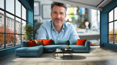 an assured business professional in a light blue shirt, resting at his desk after strategizing, with a blur of project plans behind him in a modern office environment. Wall mural