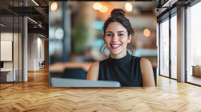 Happy Entrepreneur Working at Trendy Café.A cheerful young entrepreneur enjoys working on her laptop at a cozy, well-lit café with a vibrant, welcoming atmosphere. Wall mural