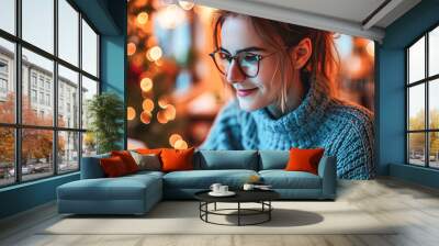 young beautiful caucasian woman wearing blue sweater and eyeglasses using silver laptop in cafe	 Wall mural