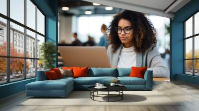 Young businesswoman using a laptop at her desk in a modern office. Portrait of an successful young creative businesswoman using PC at her workplace in the modern office. Generative Ai. Wall mural