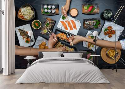 Top view of people eating Japan food on wood table together. Wall mural