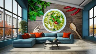 Vegetarian Thai Green Curry in bowl at wood slate background. Veg Green Thai Curry is thailand cuisine dish with green chillies paste, basil, spices and vegetables. Thai Food top view Wall mural