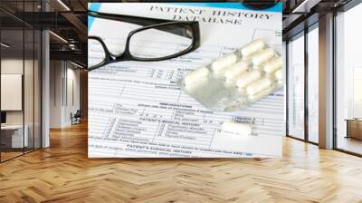 Doctor workplace. Pills, tablets, glasses on patient history dat Wall mural