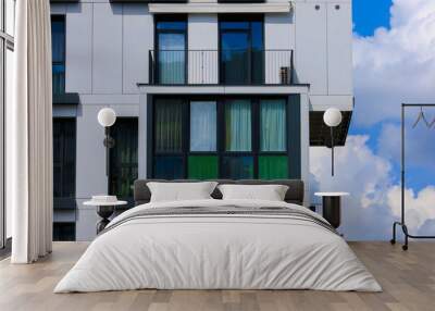 Cityscape on a summer day, modern buildings and houses against the blue sky  Wall mural