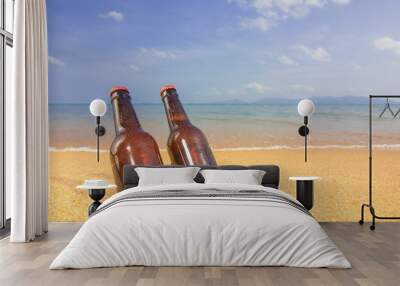 Two Brown Beer bottles on the beach on the background of the sea and sky Wall mural