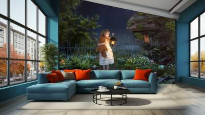 The little girl in the night in a beautiful magical forest. Girl holding an antique lantern and a toy bear. Children's fairy tale Wall mural