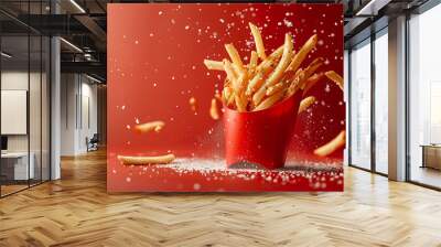 french fries bursting energetically from a red carton bo, along with salt splatters and french frieszest , set against a matte crimson background. Wall mural