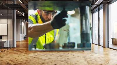 Close up hand industrial industrial plant with a tablet in hand, Engineer looking of working at industrial machinery setup in factory. Wall mural