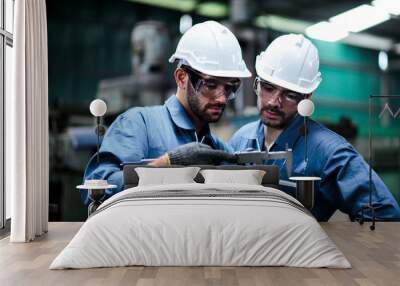 Two maintenance engineers discuss inspect relay checking information and protection system on a tablet computer in a factory. They work a heavy industry manufacturing factory. Wall mural