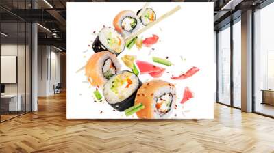 Different fresh sushi rolls with chopsticks frozen in the air on white background Wall mural