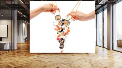 Falling sushi rolls with wooden chopsticks in female hands, isolated on white background Wall mural