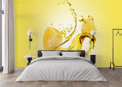 Juice splashes out from sliced lemon on yellow background Wall mural