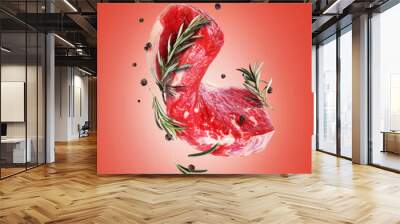 Raw beef steak with rosemary and allspice on a red background Wall mural