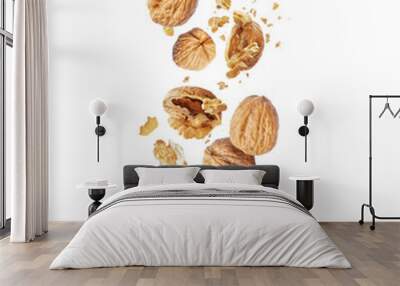 Whole and cracked walnuts close-up in the air on a white background Wall mural