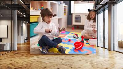 Adorable boy and girl playing supermarket game sitting on floor at kindergarten Wall mural