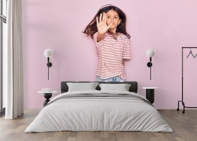 Adorable hispanic child girl wearing casual clothes smiling happy. Jumping with smile on face over isolated pink background Wall mural