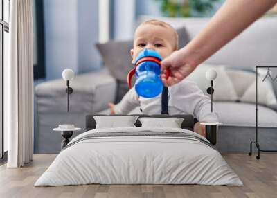 Adorable toddler drinking water standing at home Wall mural