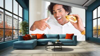 African American hungry man eating hamburger for lunch with surprise face pointing finger to himself Wall mural