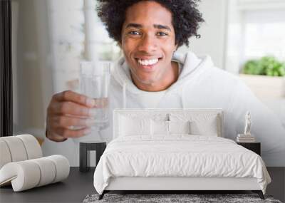 African American man drinking a glass of water at home with a happy face standing and smiling with a confident smile showing teeth Wall mural