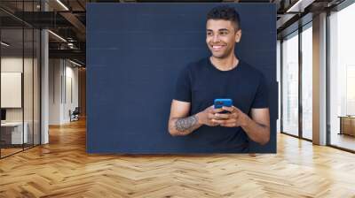 African american man smiling confident using smartphone over black background Wall mural