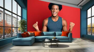 African american man with afro hair wearing sportswear screaming proud, celebrating victory and success very excited with raised arms Wall mural