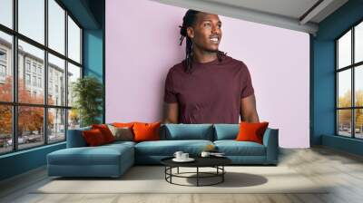 African american man with braids wearing casual clothes looking away to side with smile on face, natural expression. laughing confident. Wall mural