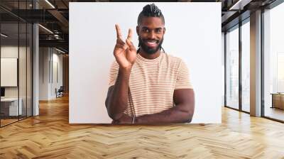 African american man with braids wearing striped t-shirt over isolated white background smiling with happy face winking at the camera doing victory sign. Number two. Wall mural