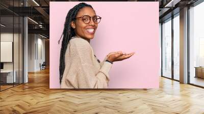 African american woman wearing casual clothes pointing aside with hands open palms showing copy space, presenting advertisement smiling excited happy Wall mural