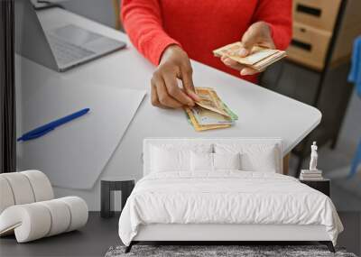 African woman counting south african rands in a modern office setting. Wall mural