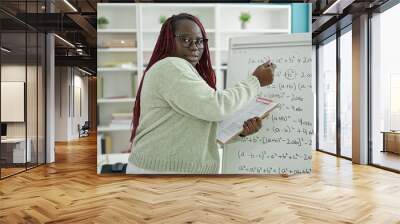 African woman with braided hair teacher teaching maths lesson at university library Wall mural