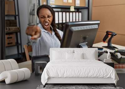 African woman working at small business ecommerce pointing displeased and frustrated to the camera, angry and furious with you Wall mural