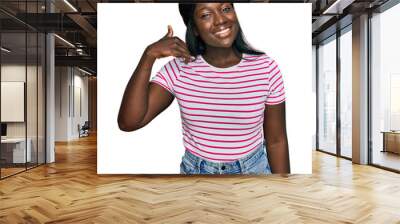 African young woman wearing casual striped t shirt smiling doing phone gesture with hand and fingers like talking on the telephone. communicating concepts. Wall mural