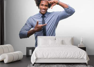 Afro american business man over isolated background smiling making frame with hands and fingers with happy face. Creativity and photography concept. Wall mural