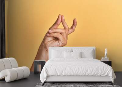 Arm and hand of caucasian man over yellow isolated background snapping fingers for success, easy and click symbol gesture with hand Wall mural