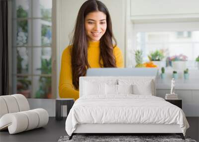 Beauitul young woman working using computer laptop concentrated and smiling Wall mural