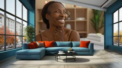 Beautiful african woman smiling in a wellness spa center with candles and plants in the background, enjoying relaxation indoors at a beauty salon Wall mural