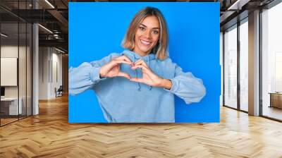 Beautiful caucasian woman wearing casual sweatshirt smiling in love showing heart symbol and shape with hands. romantic concept. Wall mural