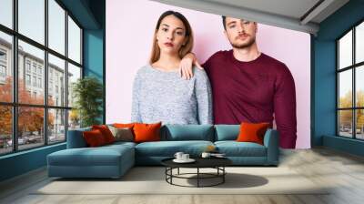 Beautiful couple wearing casual clothes relaxed with serious expression on face. simple and natural looking at the camera. Wall mural