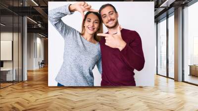 Beautiful couple wearing casual clothes smiling making frame with hands and fingers with happy face. creativity and photography concept. Wall mural