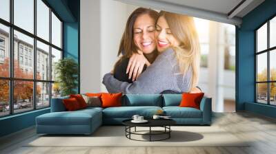 Beautiful family of mother and daughter together, hugging and kissing at home Wall mural