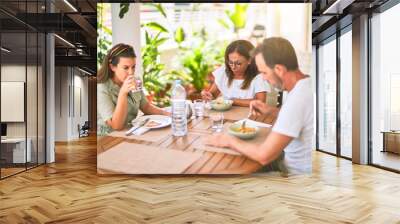 Beautiful family sitting on terrace eating foods speaking and smiling Wall mural