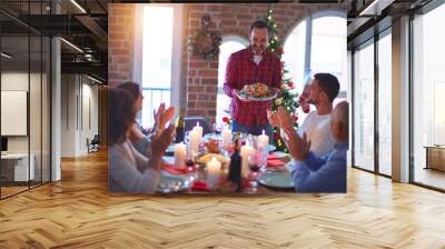 Beautiful family smiling happy and confident. Showing roasted turkey and applauding celebrating Christmas at home Wall mural