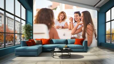 Beautiful group of women sitting at terrace speaking and smiling Wall mural