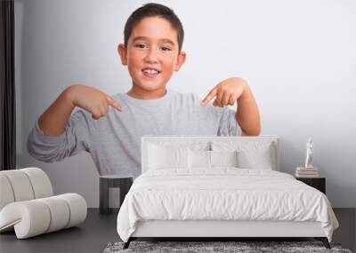 Beautiful kid boy wearing grey casual t-shirt standing over isolated white background looking confident with smile on face, pointing oneself with fingers proud and happy. Wall mural