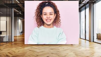 Beautiful kid girl with curly hair wearing casual clothes happy face smiling with crossed arms looking at the camera. positive person. Wall mural