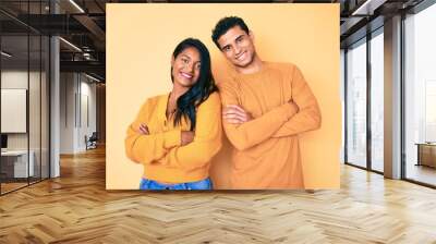 Beautiful latin young couple wearing casual clothes together happy face smiling with crossed arms looking at the camera. positive person. Wall mural